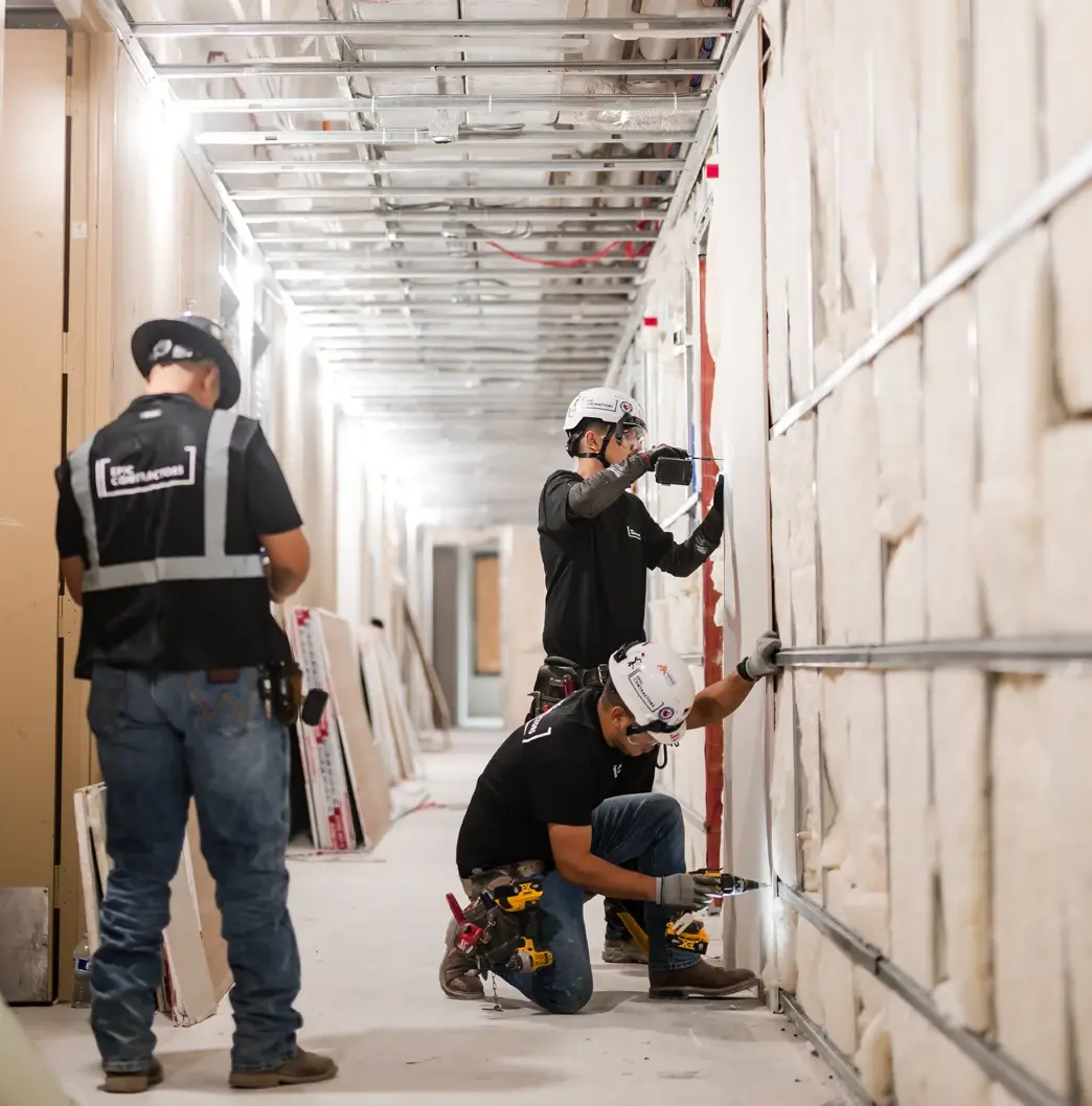 Epic Contractors crew hanging drywall along a residential corridor at The Watt at Westlake in Houston