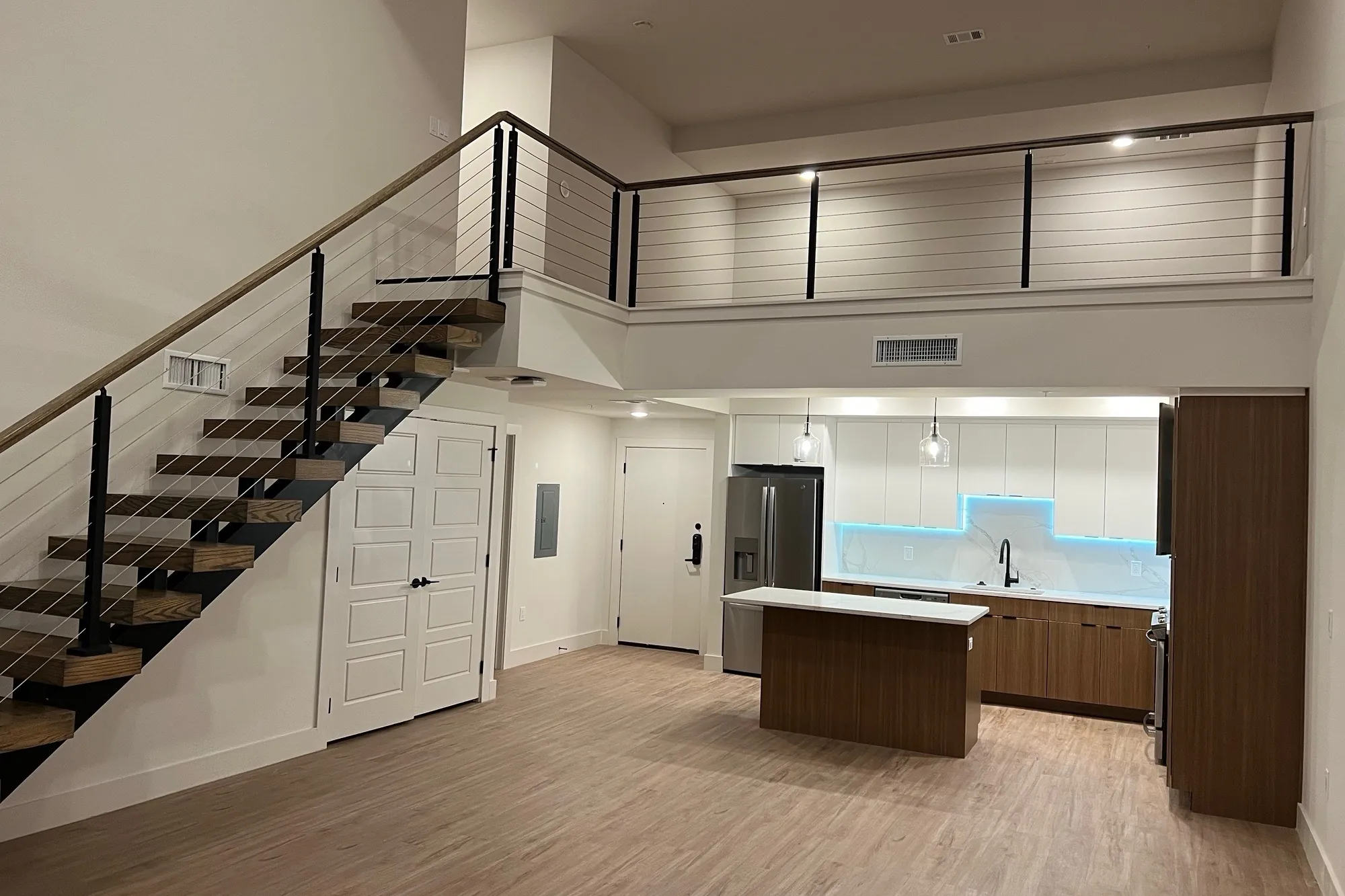 Two-story loft residence at Elev8 Luxury Apartments with framed stair wall and finished drywall