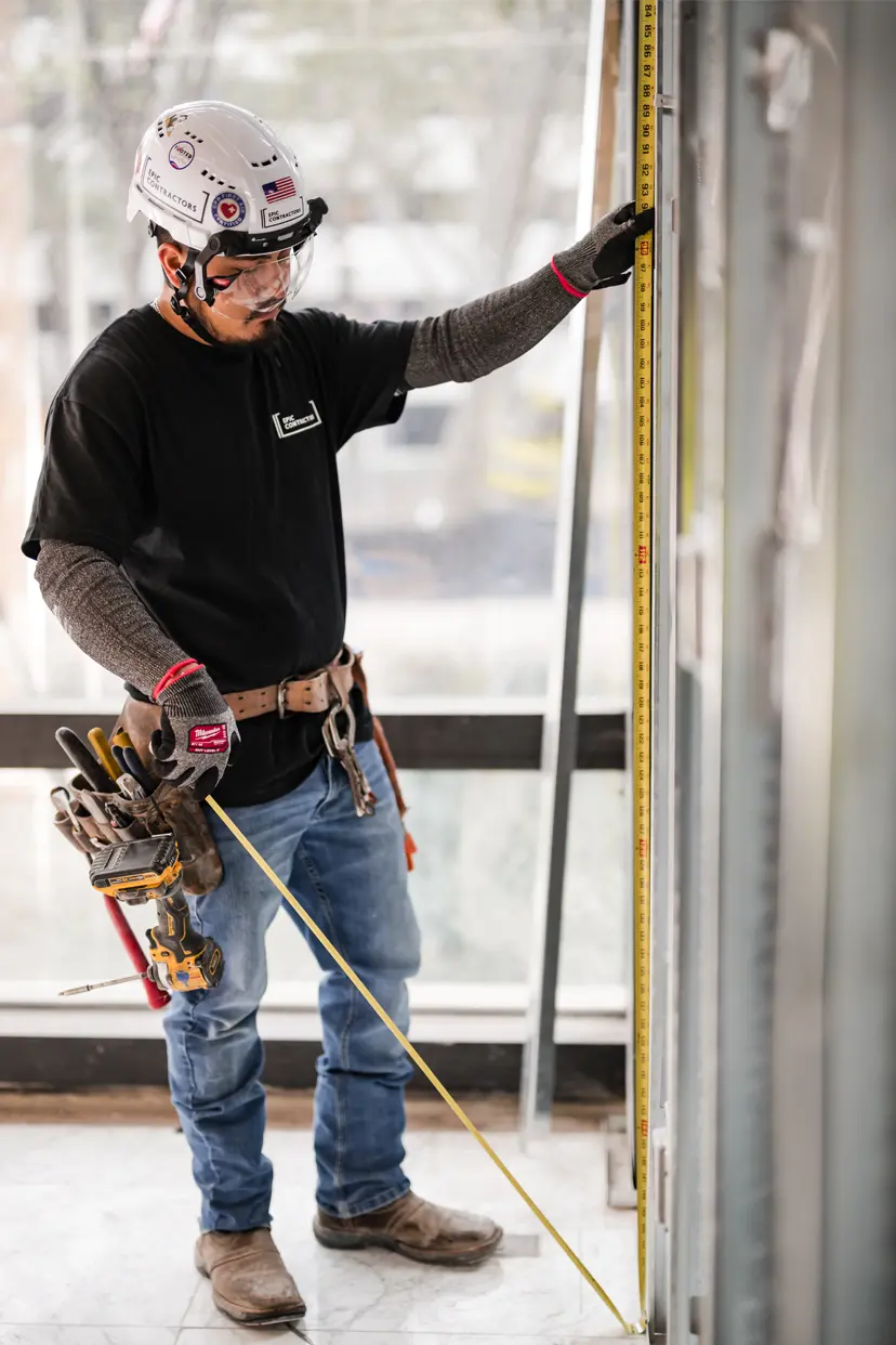 contractor-measuring-wall Contractor measuring framing for a wall