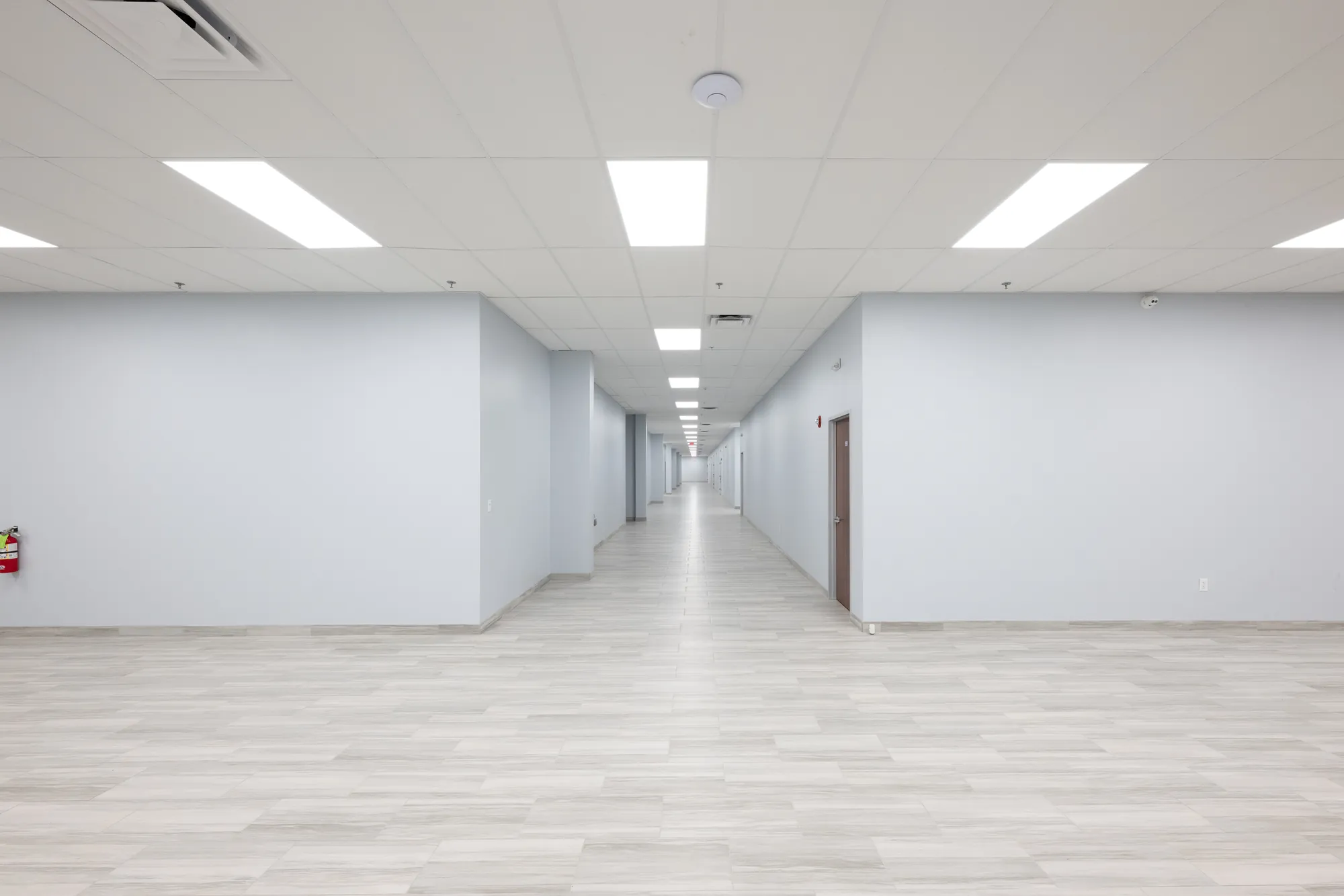 Finished corridor with acoustical ceilings, drywall, and door hardware at the Mountain of Fire Convention Center, Houston — delivered by Epic Contractors