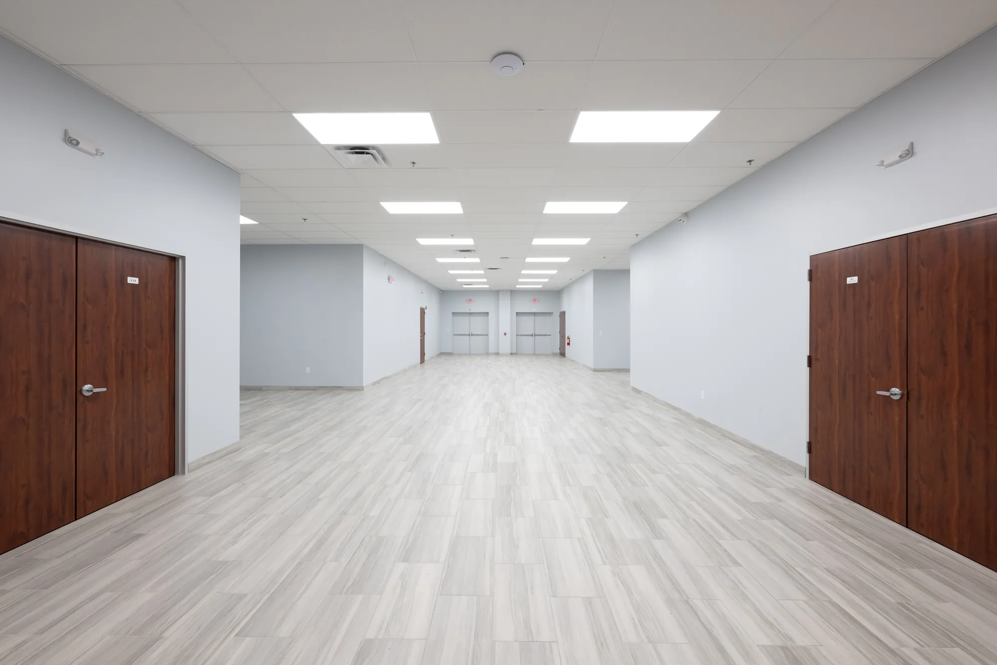 Finished corridor with acoustical ceilings, painted drywall, and wood door hardware at the Mountain of Fire Convention Center, Houston — delivered by Epic Contractors