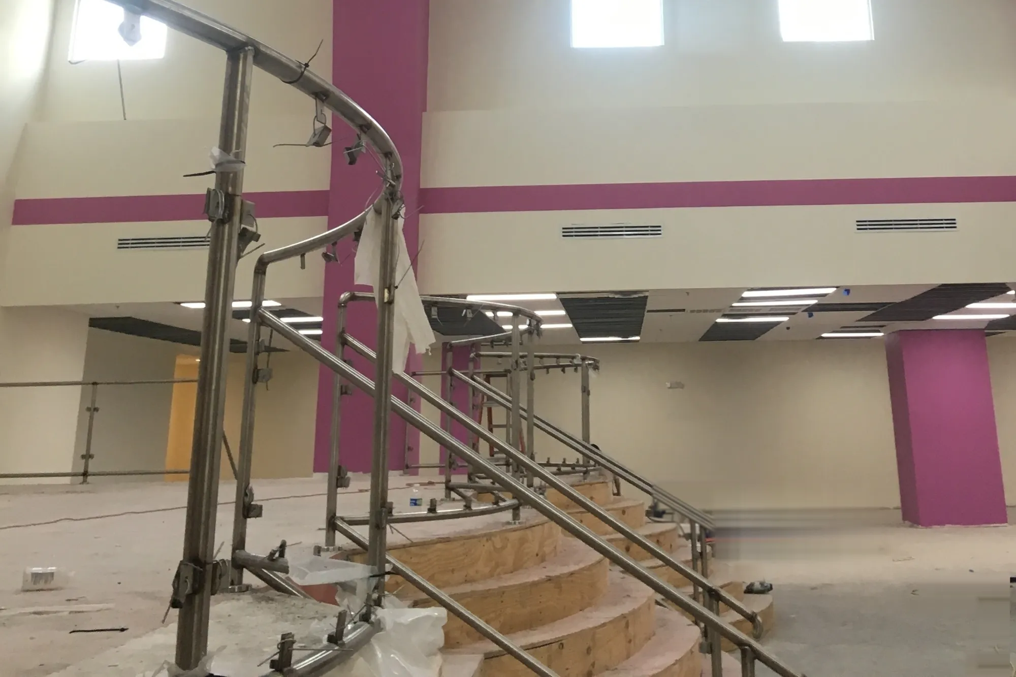 Framed and finished stage with curved stair, nearing completion — Mountain of Fire Ministries, Houston