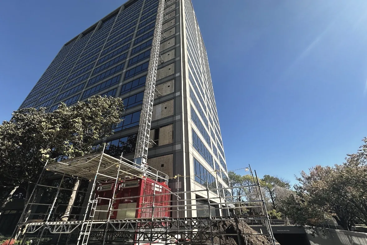 The Watt at Westlake — 19-story office tower during full gut demolition, construction hoist and scaffolding at the base