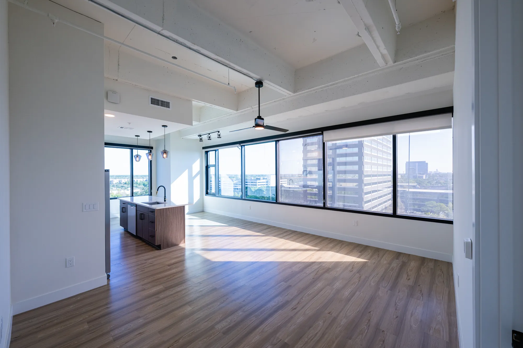 Converted residential unit with window walls at The Watt at Westlake — interior framing and drywall for the office-to-residential conversion