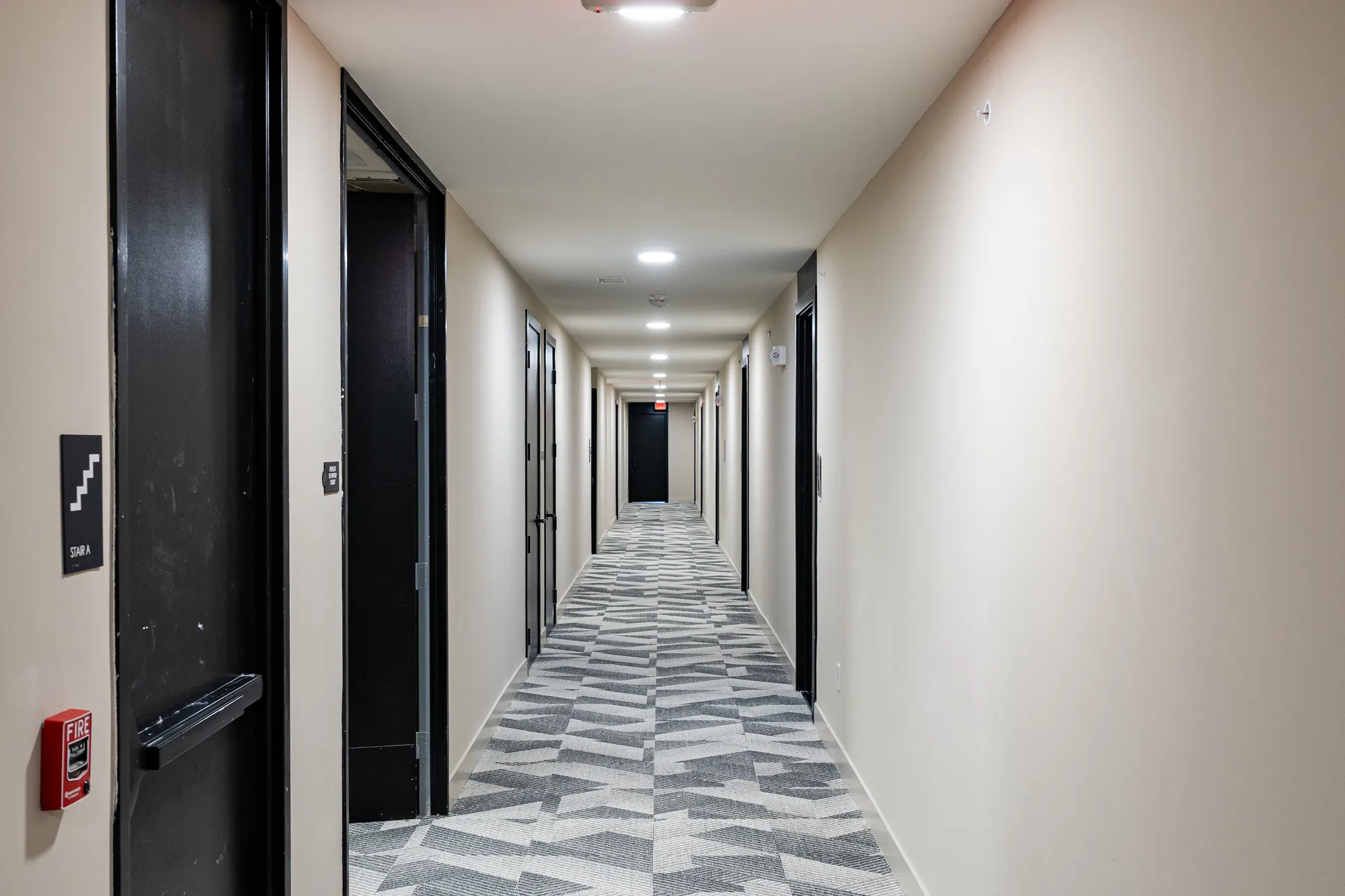 Finished residential corridor at The Watt at Westlake — Level 5 drywall finish and ceilings by Epic Contractors